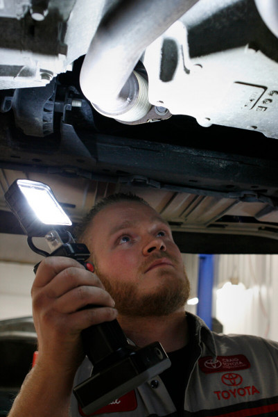 Mechanic using LED work light bz401-5 under car Mechanic using LED work light bz401-5 under car