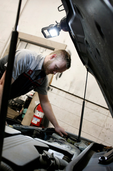 Mechanic using BriteZone LED work light to look under hood