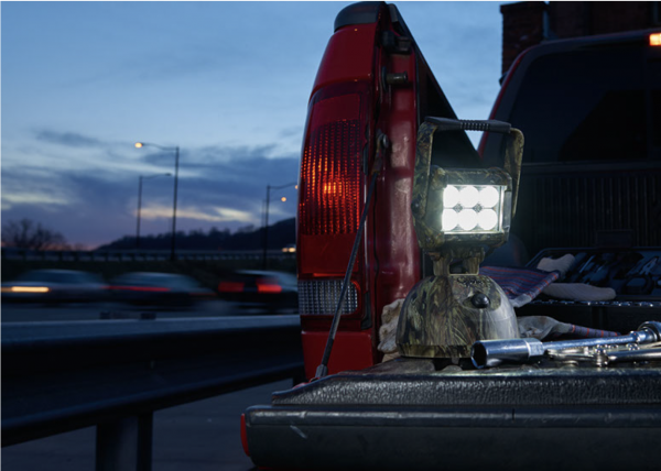 Luz LED camuflada usándose al cambiar la llanta de un camión de noche