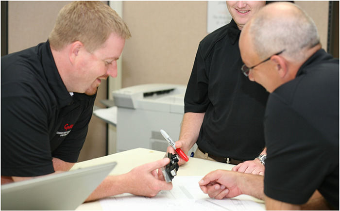 Engineers around a table inspecting a new lighting product