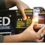 Woman using the Try Me feature on LED Bulb Display
